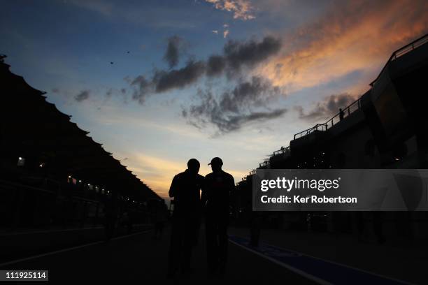 Lewis Hamilton of Great Britain and McLaren and his father Anthony Hamilton walk together at dusk in the pitlane following qualifying for the...