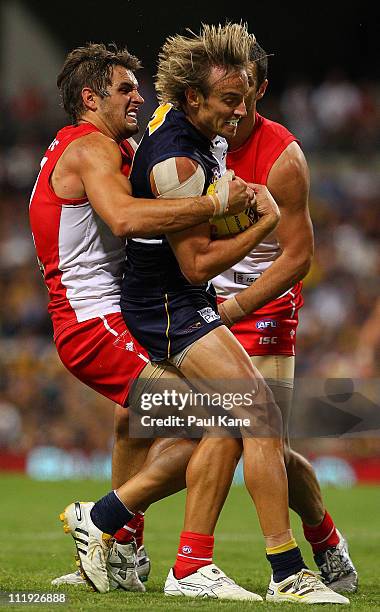 Mark Nicoski of the Eagles gets tackled by Josh Kennedy of the Swans during the round three AFL match between the West Coast Eagles and the Sydney...