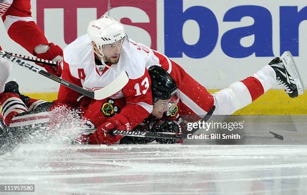 Tomas Kopecky of the Chicago Blackhawks gets squished by Pavel Datsyuk of the Detroit Red Wings on April 10, 2011 at the United Center in Chicago,...