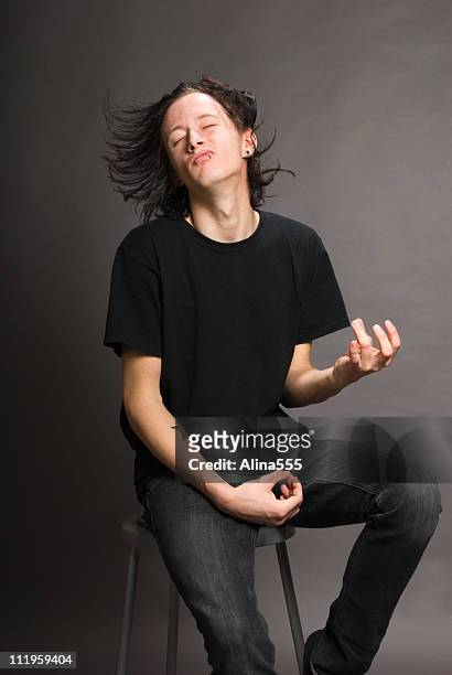 young man with long flying hair  playing air guitar - air guitar stock pictures, royalty-free photos & images