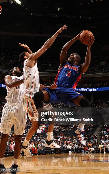 Rodney Stuckey of the Detroit Pistons shoots against Garrett Temple of the Charlotte Bobcats on April 10, 2011 at Time Warner Cable Arena on the...