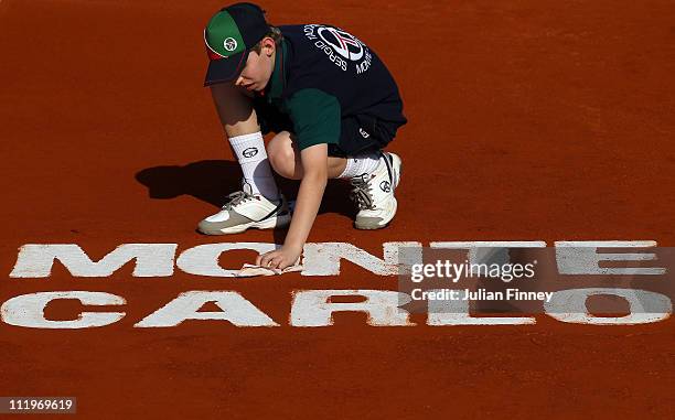 Ball boy cleans the Monte Carlo Logo during Day Two of the ATP Masters Series Tennis at the Monte Carlo Country Club on April 11, 2011 in Monte...