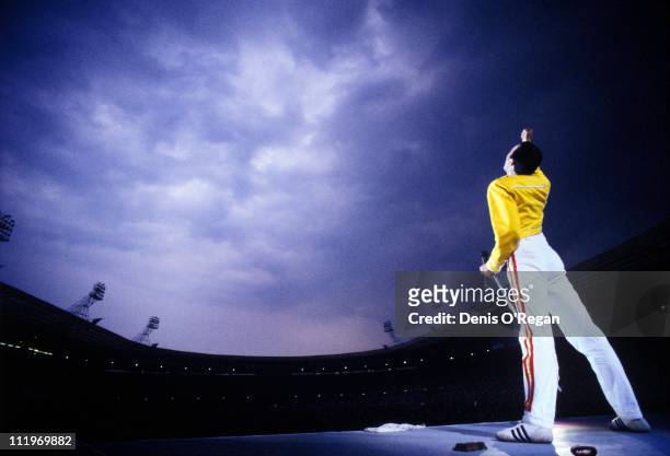 Singer Freddie Mercury performing with British rock group Queen at Wembley Stadium, London, 1986.