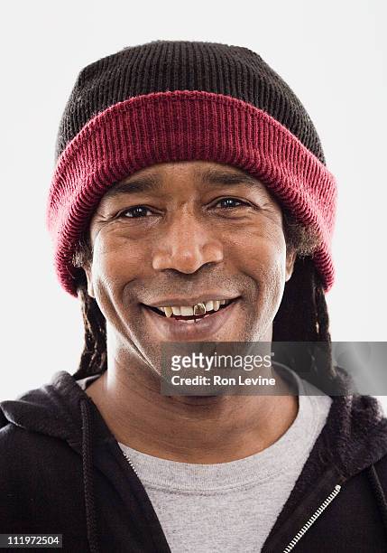 smiling man with gold tooth wearing a toque - capped tooth stock-fotos und bilder