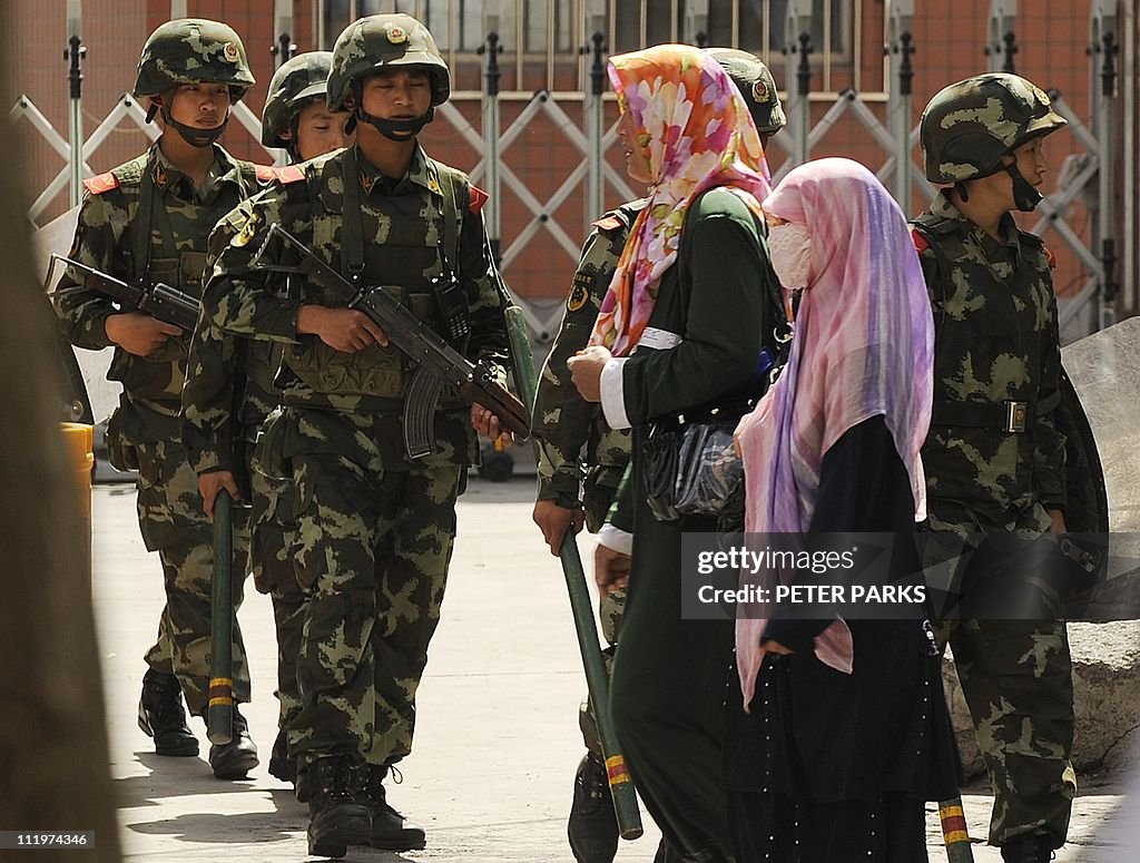 Muslim ethnic Uighur women pass a Chines