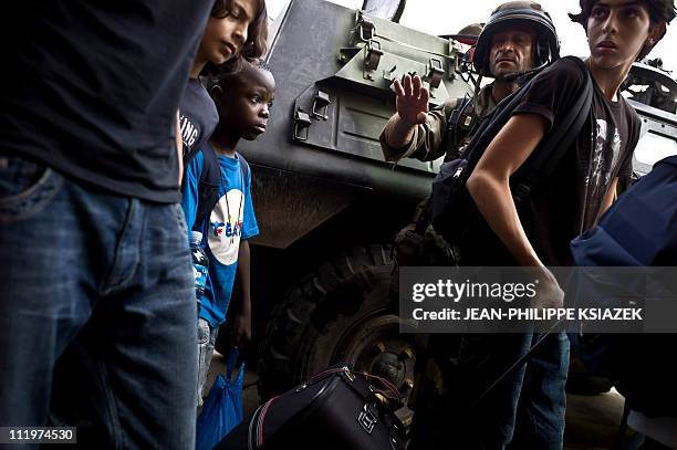 In this picture taken on April 7, 2011 a French soldiers speaks to civillians prior to their evacuation in Abidjan. A spokesman for Ivory Coast...