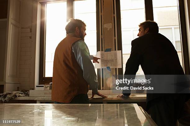 builder talking to architect about plans - foundations conversations with suits stock-fotos und bilder