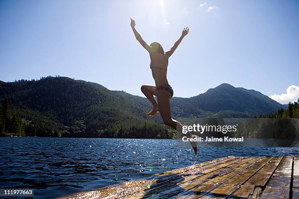 dock jumping into lake on sunny day with blue sky - okanagan valley stock-fotos und bilder