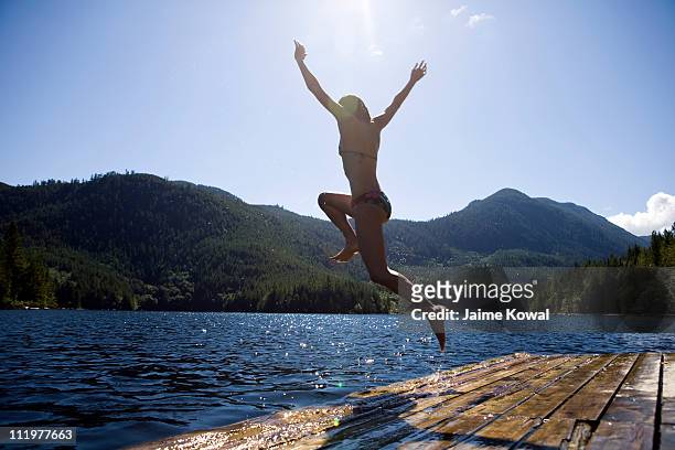 dock jumping into lake on sunny day with blue sky - kelowna stock pictures, royalty-free photos & images