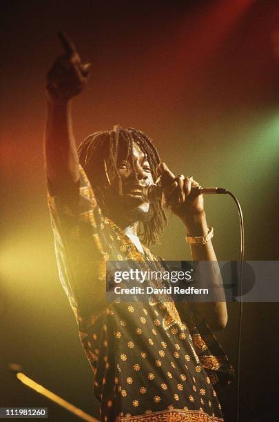 Peter Tosh , Jamaican reggae musician, singing into a microphone during a concert, circa 1975.