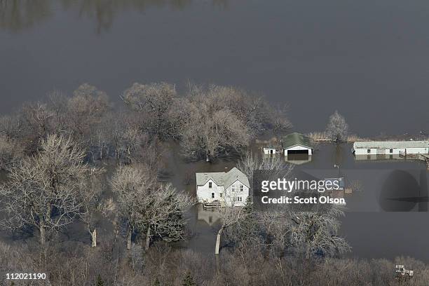 Farmhouse is surrounded by floodwater from the Red River on April 11, 2011 near Fargo, North Dakota. Although the Red River crested in Fargo on...