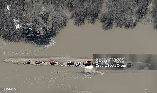 Vehicles and farm equipment are stranded on a flooded stretch of road April 11, 2011 near Fargo, North Dakota. Although the Red River crested in...