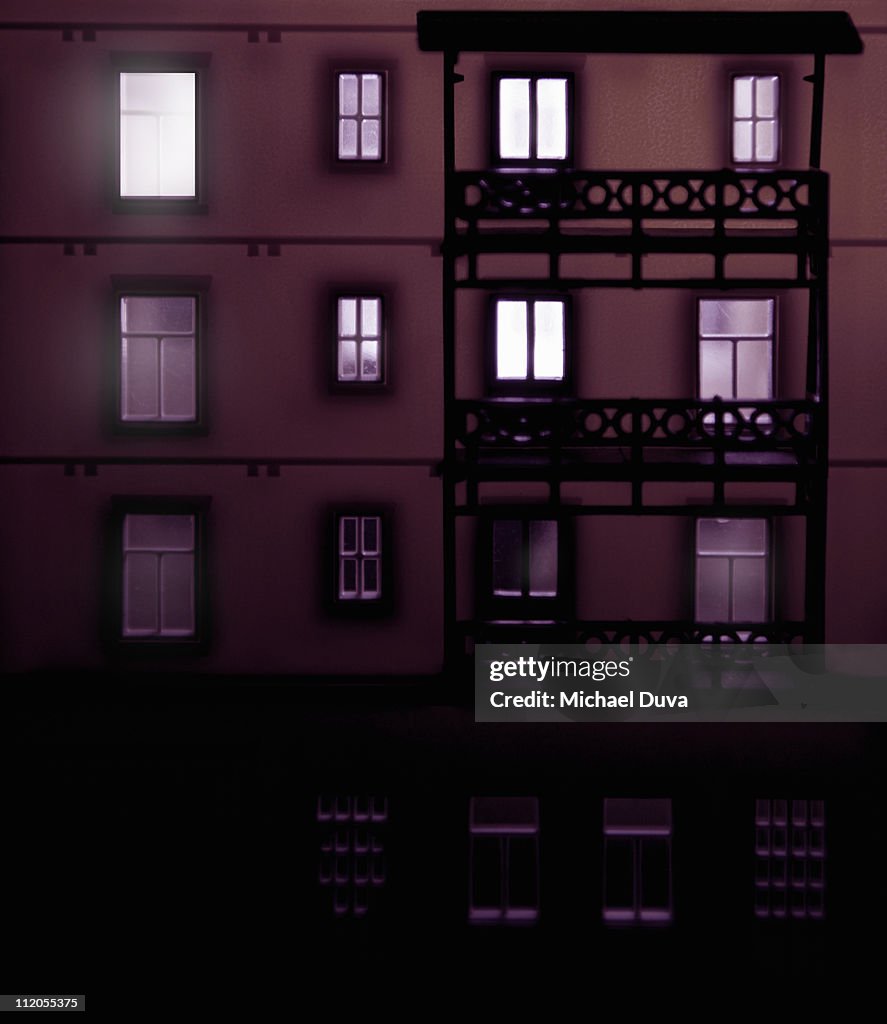 Apartment building at night with lights on inside