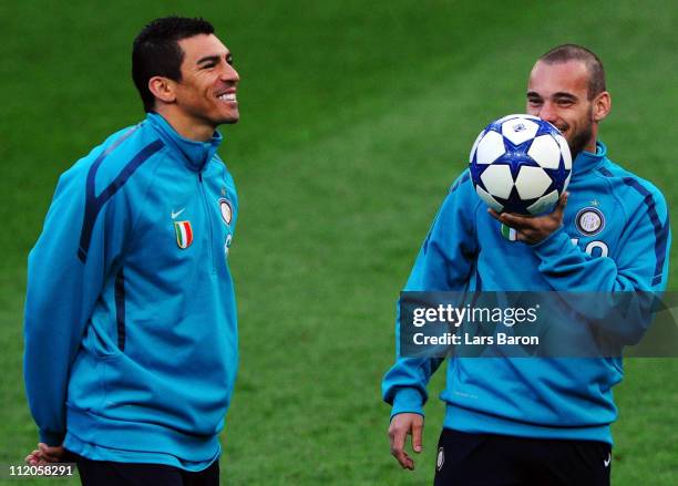 Lucio smiles next to Wesley Sneijder during a Inter Milan training session ahead of the UEFA Champions League quarter final second leg match against...