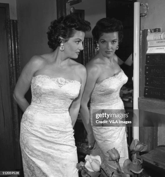 Jane Russell, posed, looking in mirror, 1957.