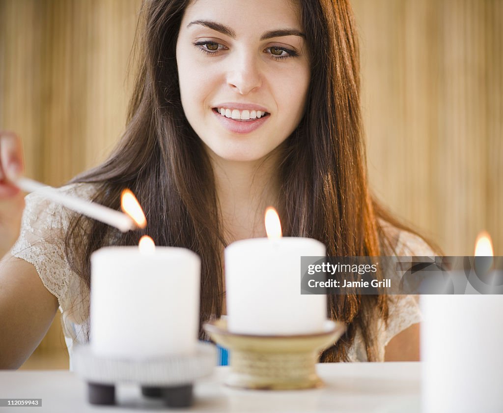 Young woman lighting candles