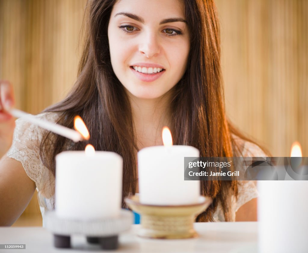 Young woman lighting candles