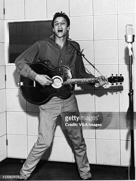 Marty Wilde, playing guitar and singing in recording studio, 1957.