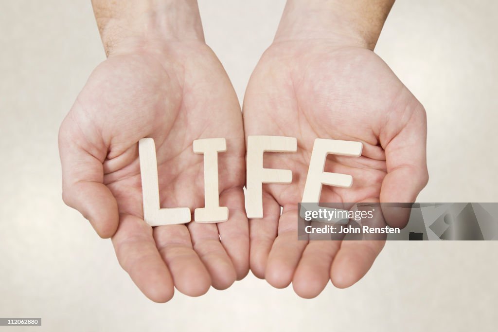 Hands holding letters spelling words