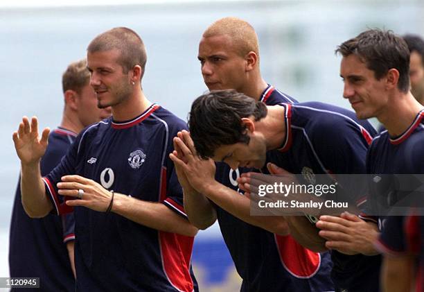 David Beckham, Wes Brown, Ronny Johnsen and Gary Neville of Manchester United perform a Sawaddee at the end of a training session held at the...