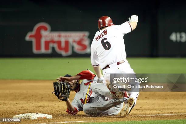 Stephen Drew of the Arizona Diamondbacks collides with relief pitcher Brian Tallet of the St. Louis Cardinals as he is tagged out at first base...