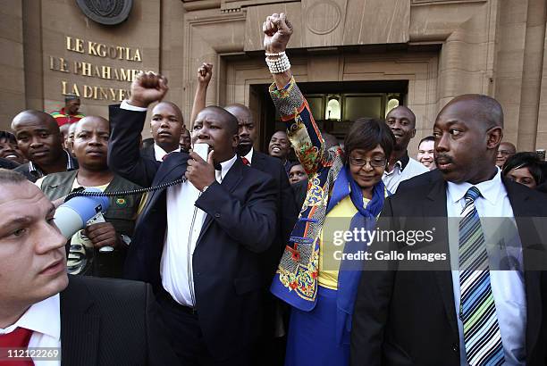 Youth League president Julius Malema and ANC stalwart Winnie Madikizela-Mandela, surrounded by members of Malema's security team, raise their fists...