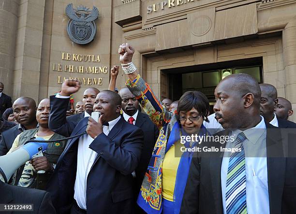 Youth League president Julius Malema and ANC stalwart Winnie Madikizela-Mandela, surrounded by members of Malema's security team, raise their fists...