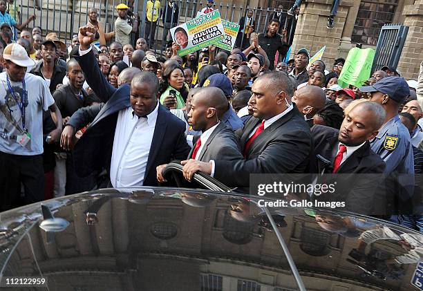 Youth League president Julius Malema, surrounded by members of his security team, raises his fist as he leaves the High Court on April 12, 2011 in...