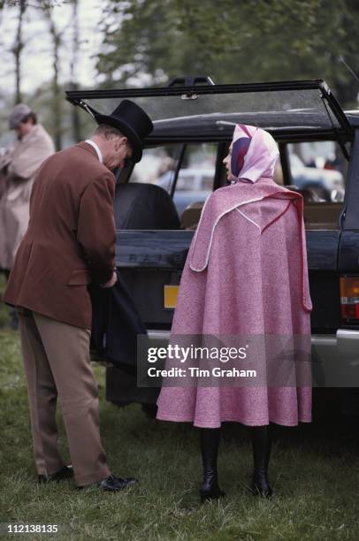 Prince Philip and Queen Elizabeth II, wearing a pink cape, at the Royal Windsor Horse Show, held at Home Park in Windsor, Berkshire, England, Great...