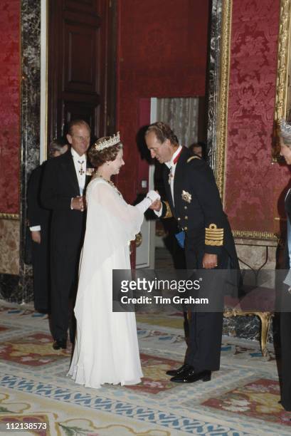 Queen Elizabeth II and Prince Philip meeting King Juan Carlos I of Spain at the Palacio Real de Madrid, in Madrid, for a state banquet in Spain, 18...
