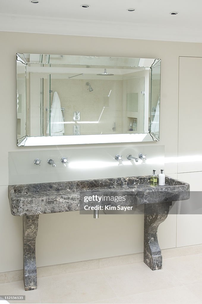 Interior of mirror and trough sink in bathroom