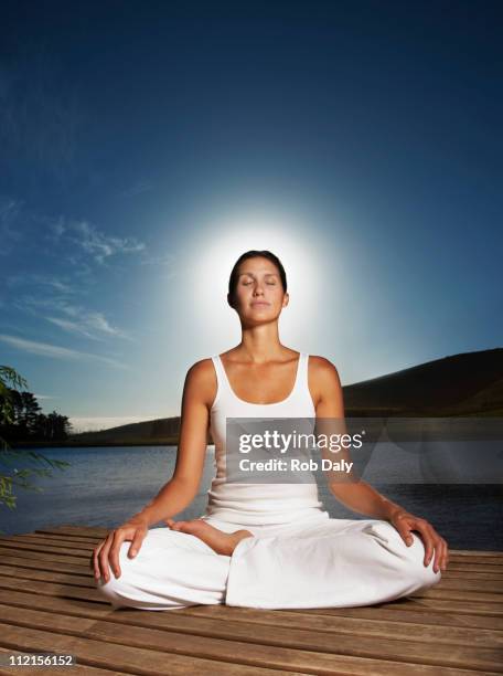 woman practicing yoga on pier - meditation concentration stock pictures, royalty-free photos & images