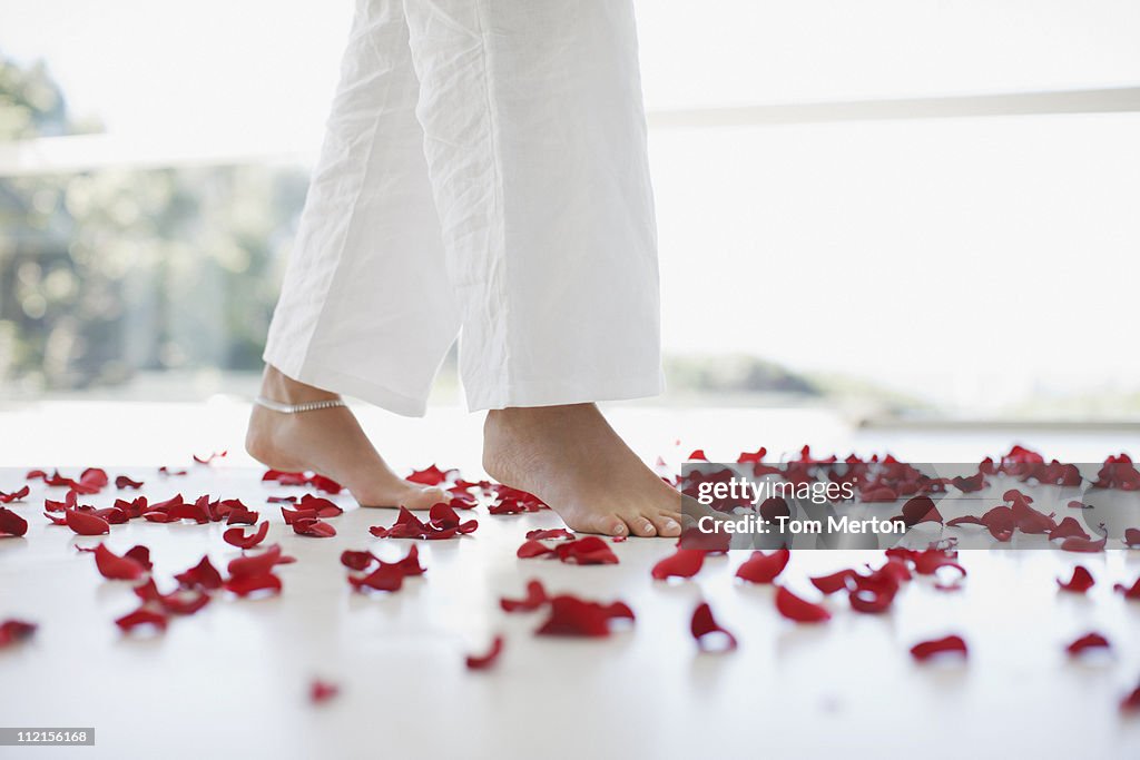 Woman walking through flower petals on floor