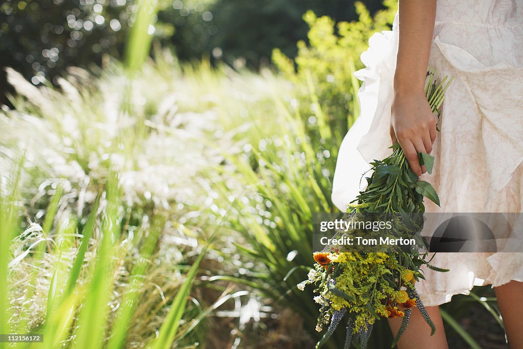Woman carrying flowers in garden