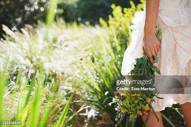 woman carrying flowers in garden - floral dress stock pictures, royalty-free photos & images