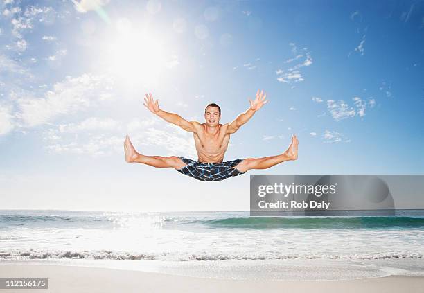 homem saltar no ar na praia mid - legs apart imagens e fotografias de stock