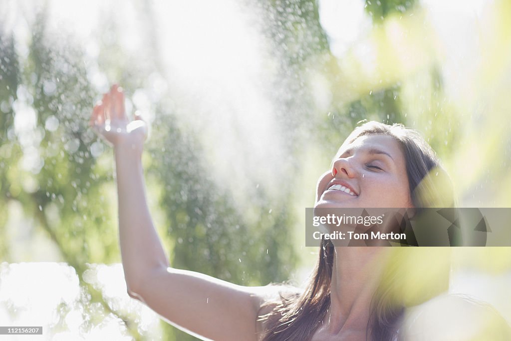 Woman standing outdoors with arms raised