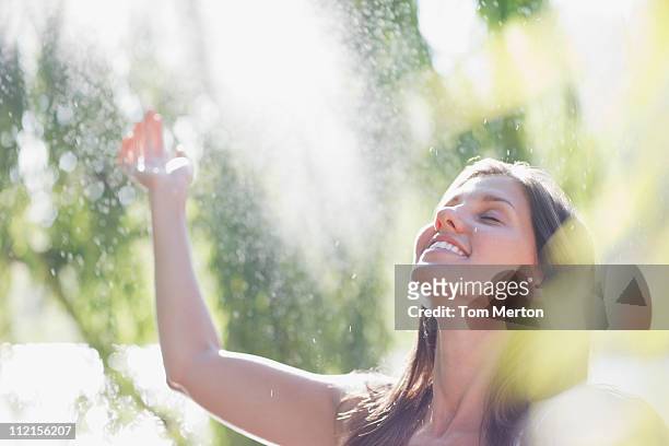 woman standing outdoors with arms raised - woman happy raised arms closed eyes stock pictures, royalty-free photos & images