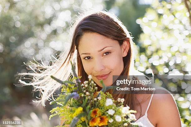 smiling woman holding bouquet of flowers - beautiful woman spring stock pictures, royalty-free photos & images