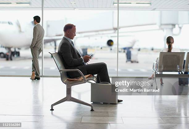 geschäftsmann warten in flughafen - airplane phone stock-fotos und bilder