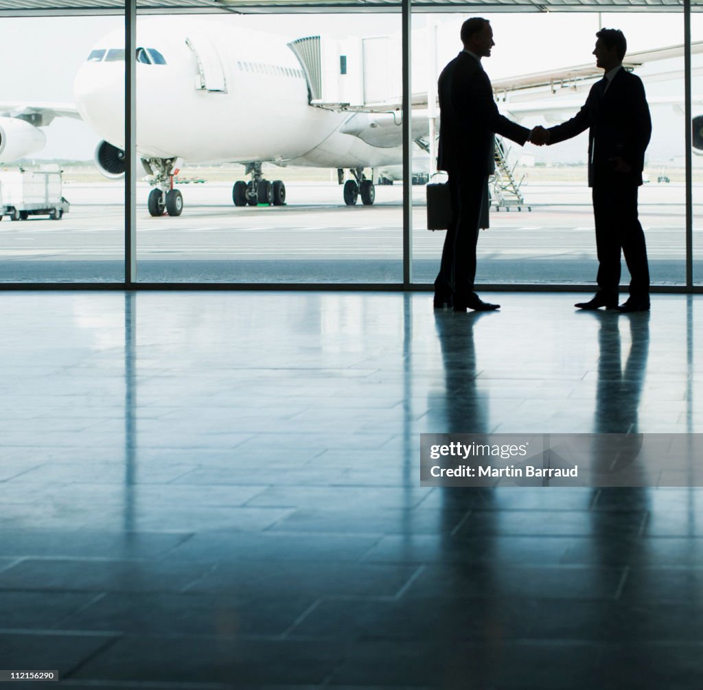 Business people shaking hands in airport