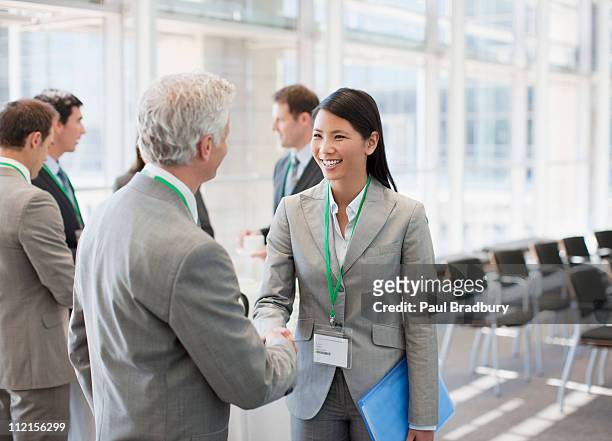 business people shaking hands at seminar - formal businesswear stock pictures, royalty-free photos & images