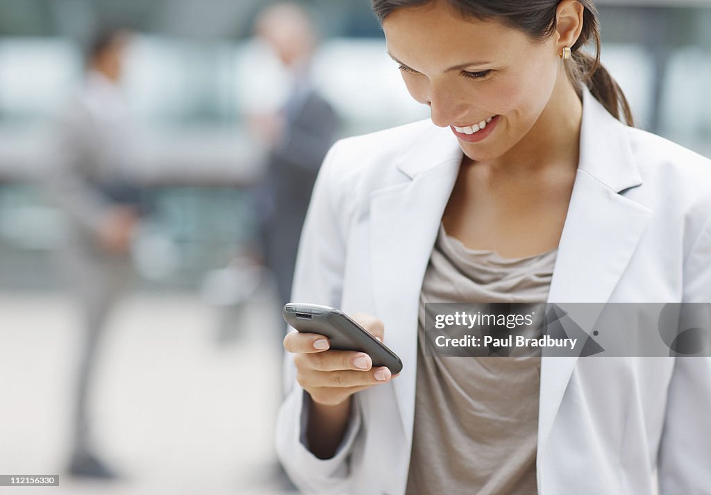 Businesswoman text messaging on cell phone