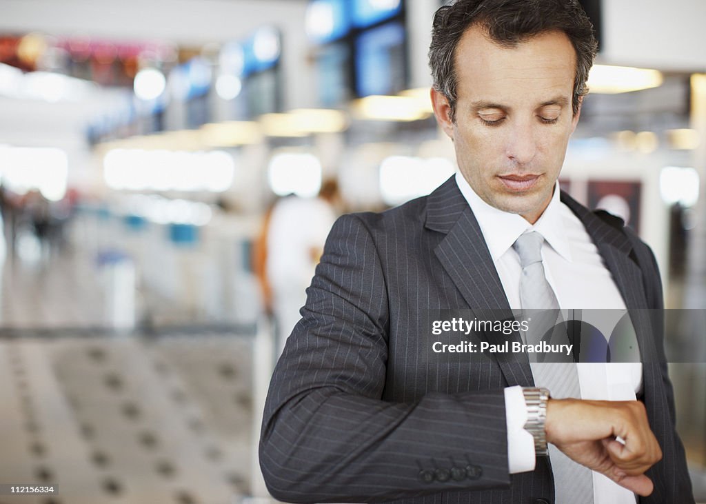 Businessman checking watch in airport