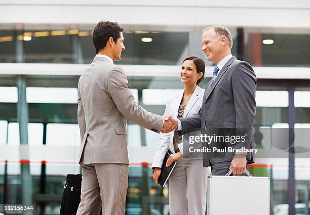 businessmen shaking hands outdoors - 3 men standing outside stockfoto's en -beelden