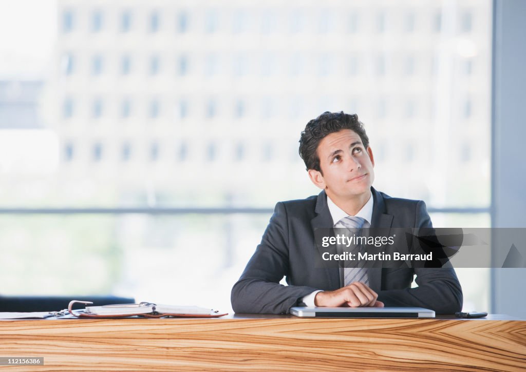 Businessman sitting at desk thinking