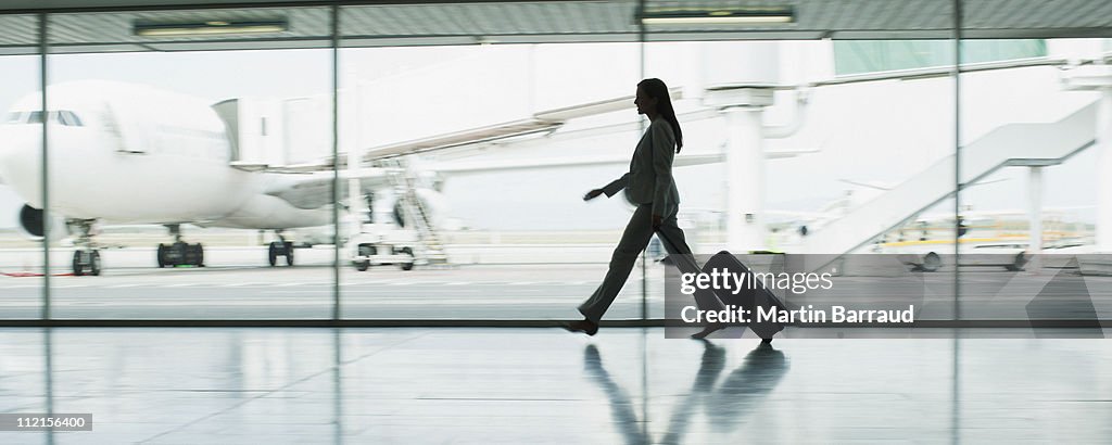 Geschäftsfrau mit Koffer am Flughafen
