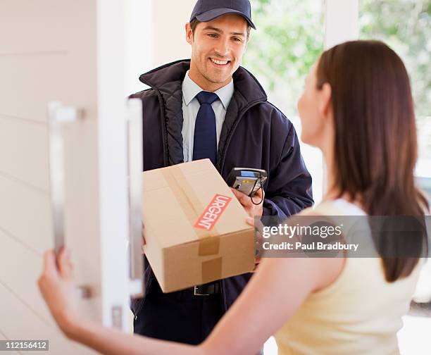 delivery man handing box to woman - delivery driver with handheld device stock pictures, royalty-free photos & images