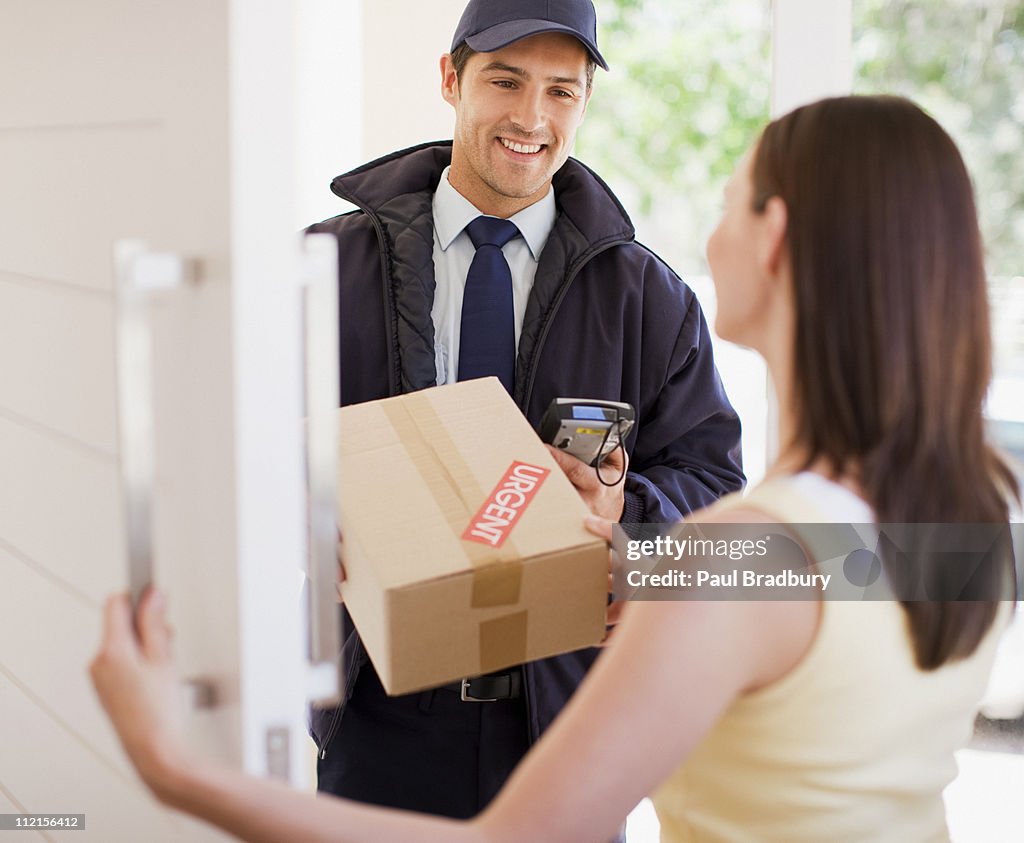 Delivery man handing box to woman