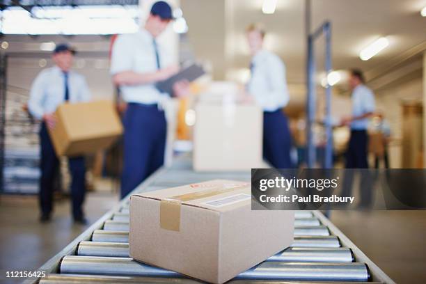 caixas na correia transportadora na área de envio - conveyor belt imagens e fotografias de stock